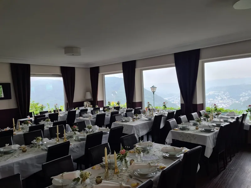 Restaurantsaal mit gedeckten Tischen und Panoramafenstern bei Tag