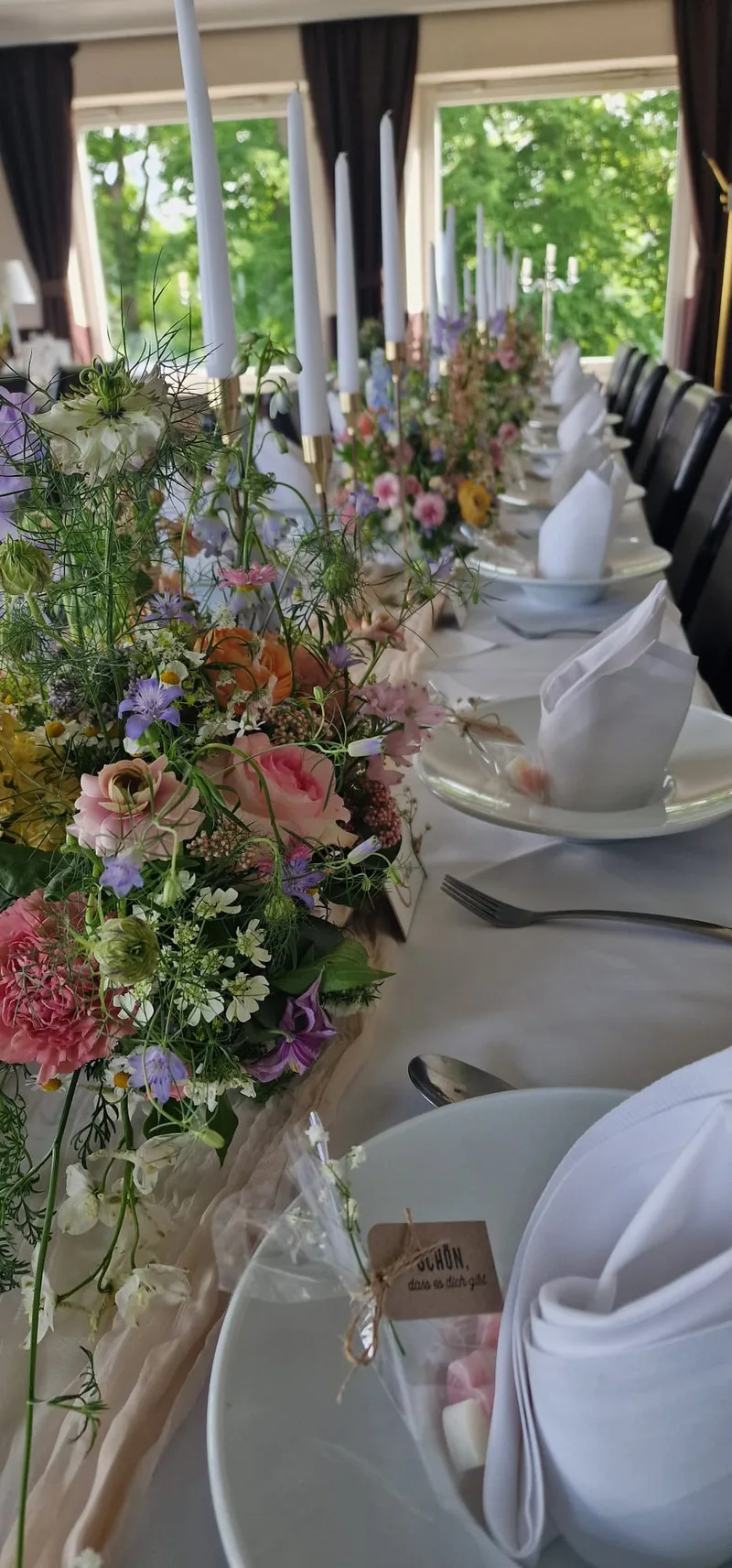 Tischdekoration mit Wildblumen, Kerzen und Tischkarten